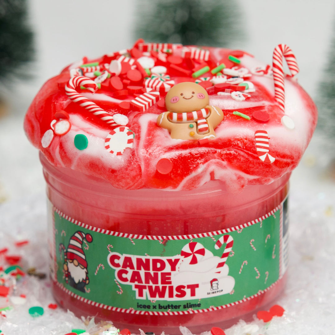 Candy Cane Twist slime in a jar featuring a vibrant red and white swirl texture, topped with a gingerbread man charm, candy cane charms, and festive sprinkles