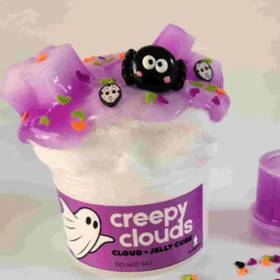 image of white cloud slime topped with jelly cube purple slime and cute spider charm, creepy polymer slices and bats