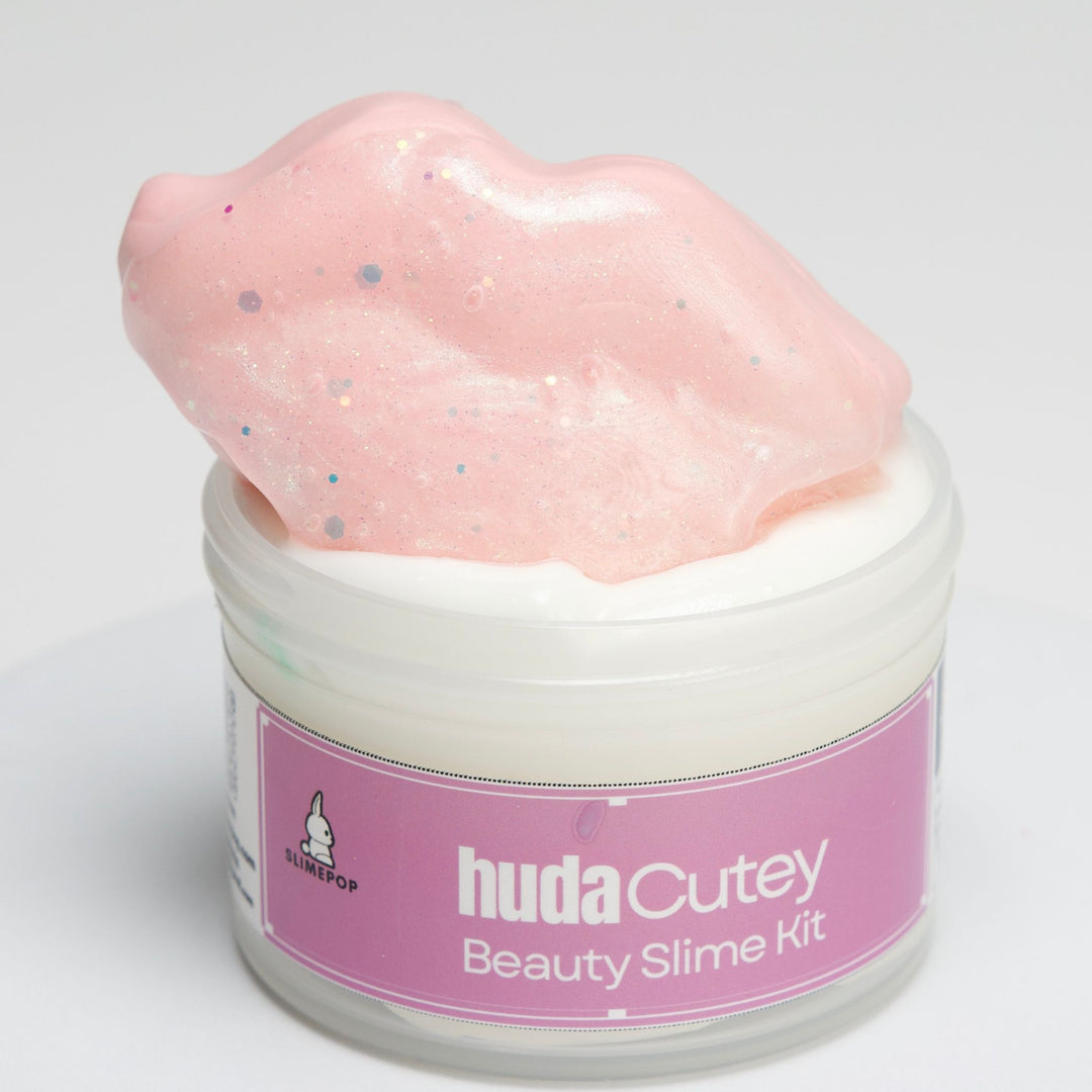 Huda Cutie DIY slime kit with a lip-shaped clay topper, thick and glossy base, and two pink sparkly lip-gloss slime toppers