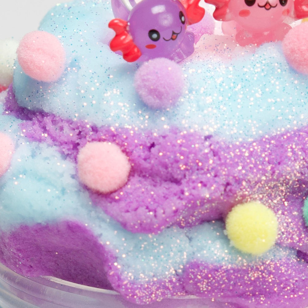 close up on cloud slime, blue and violet with axolotl charm and pompoms